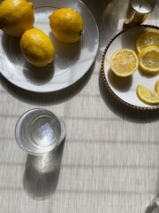 glass of water with lemons on plate, flat lay, limoncello  