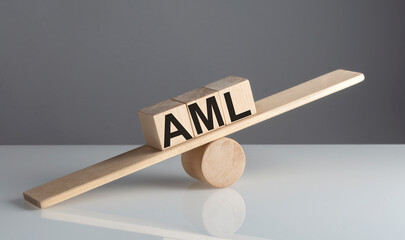 AML on wooden cubes on a wooden balance , business concept