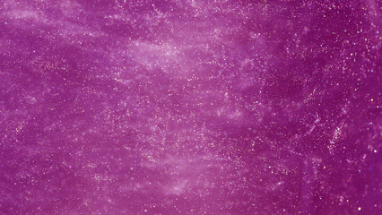 Purple glitters in water, abstract background.