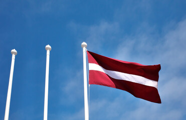 Flag of the Republic of Latvia and three flagpoles.