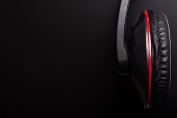 Black and red headphones on a dark background with copyspace
