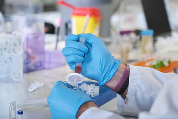 Close up of a scientist in white lab coat filter sample at chemical laboratory.