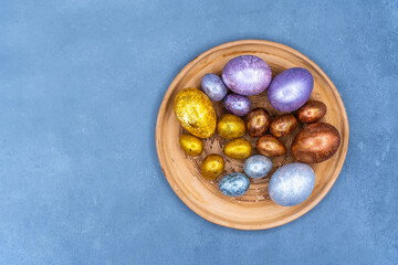 Easter background with golden and colored eggs. Happy easter background top view