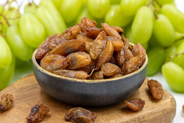 Dried raisins on a white background. Raw grapes and raisins. Healthy and fresh nuts. close-up....