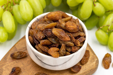 Dried raisins on a white background. Raw grapes and raisins. Healthy and fresh nuts. close-up....