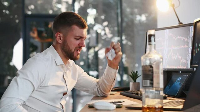 Conception of failure. Drinking alcohol. Stock broker in formal clothes is working indoors in the office