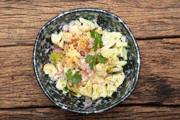 Healthy food cauliflower salad in bowl dish on wood background.