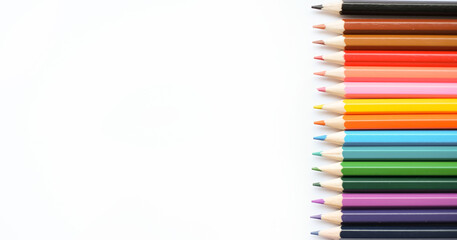 A set of colored pencils isolated on a white background in banner format. Place for text