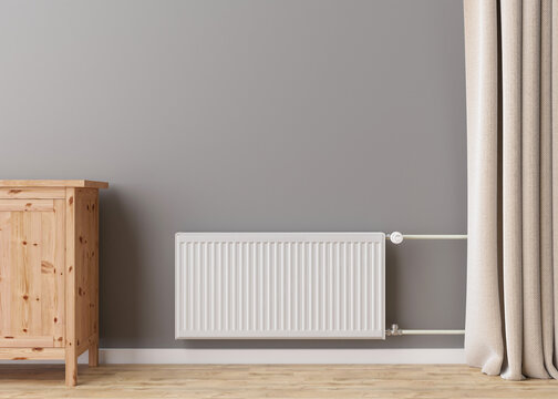 White heating radiator with thermostat on grey wall in modern room. Central heating system. Free, copy space for your text. 3D rendering.