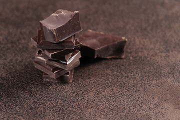 Broken dark chocolate and cocoa powder on a table
