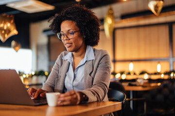 Confident African-American novelist, writing her story on her laptop.