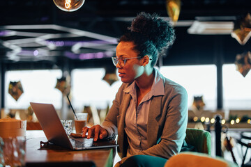 Concentrated african-american businesswoman, checking the yearly income of her bar.