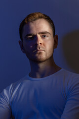 Contemporary young man posing in various poses in studio.Futuristic neon lighting.Portrait photo shoot.