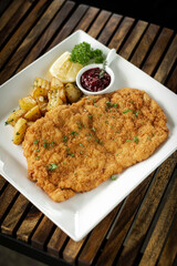 german veal schnitzel cutlet with potato and red berry sauce