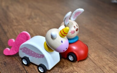 wooden toys on wheels, unicorn and bunny on wooden background