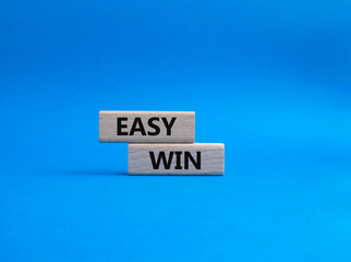 Easy win symbol. Wooden blocks with words 'Easy win'. Beautiful blue background. Business and 'Easy win' concept. Copy space.