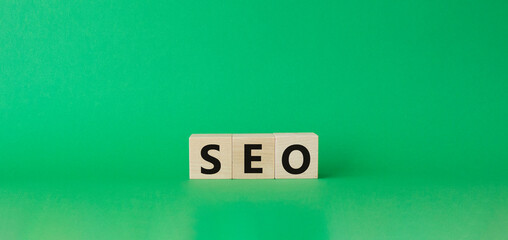 Seo symbol. Wooden blocks with words 'Seo'. Beautiful green background. Business and seo concept. Copy space.