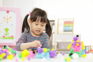 young girl playing creative 3d shape toy for homeschooling