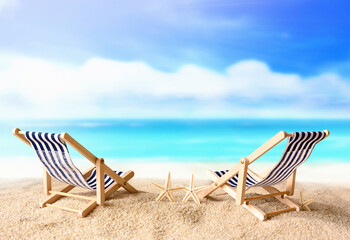 Fototapeta na wymiar Vacation holidays background concept - two beach lounge chairs on summer beach.