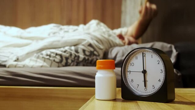 Slow motion. Morning intake of vitamins or medications by time.  Time for the concept of drugs. An elderly sick person chooses with the help of medical tablets for hands from the table
