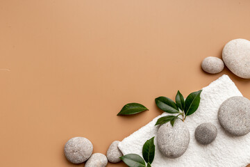 Fototapeta na wymiar Spa massage stones with green leaves. Beauty treatment background
