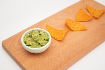 Nachos and guacamole on wooden background