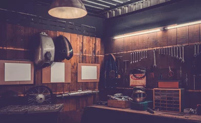 Fototapeten Werkstattszene. Alte Werkzeuge, die in der Werkstatt an der Wand hängen, Werkzeugregal an Tisch und Wand, Vintage-Garage-Stil © Win