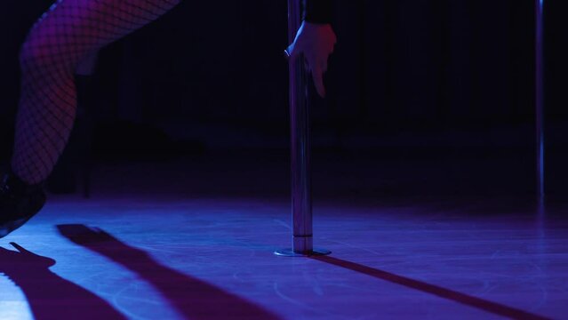 Slender legs of pole dancer in high heels, close-up. Close-up of stripper shoes in the club. Pole dance.