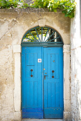 Fototapeta na wymiar Blue old textured door in a stone wall, Rovinj, Croatia, Europe 