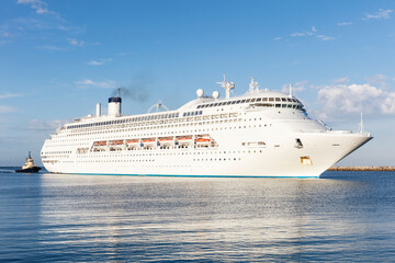 Large Luxury Cruise Liner entering a Harbour with calm water showing reflections. 