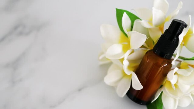 natural beauty and organic ingredients in skincare, apothecary skincare bottle with tropical flowers bokeh