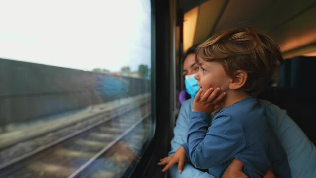 Mother wearing surgical face mask inside train holding child
