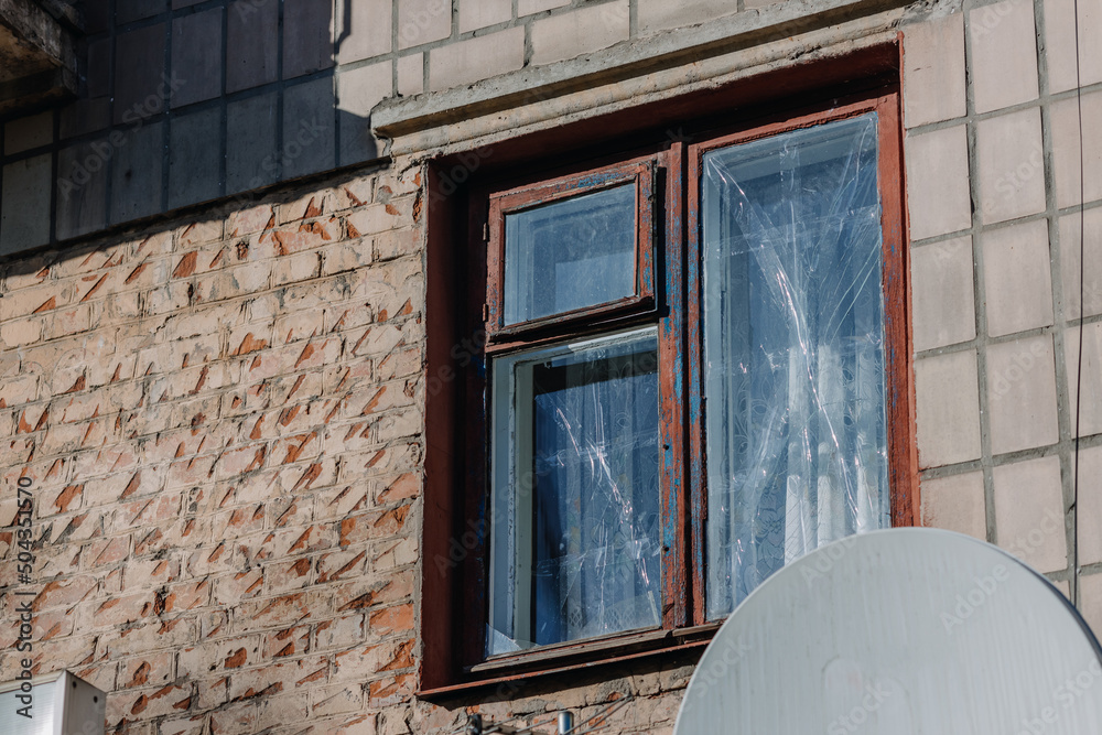 Wall mural  Taped window in an apartment building in the city of Chernihiv near Kyiv in northern Ukraine. Russia's war against Ukraine in 2022. Airstrike