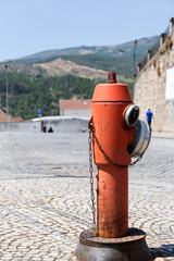 Red fire hydrant on cobblestone street