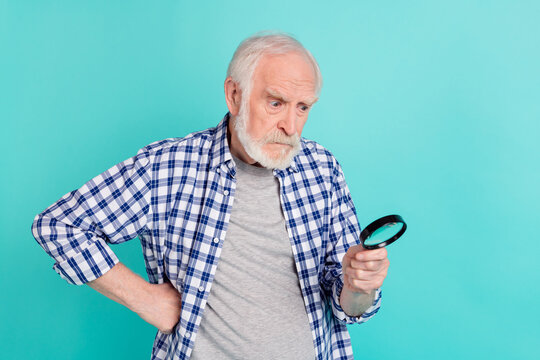 Portrait of aged person put arm waist hold watch magnifier isolated on turquoise color background