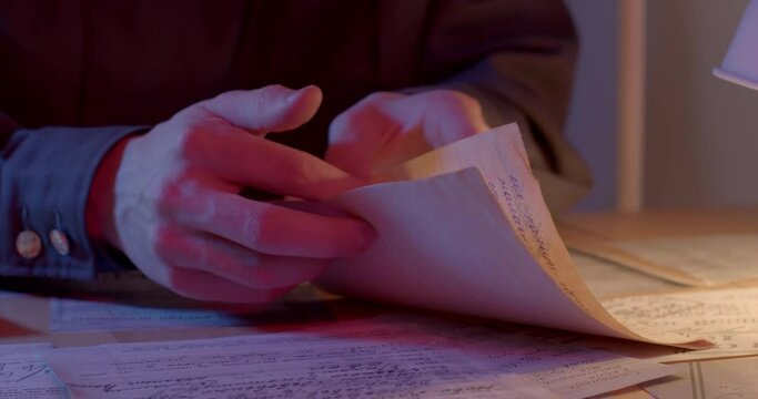 The hands of the worker find the necessary information in paper documents. Finger points to search. The success of finding evidence.