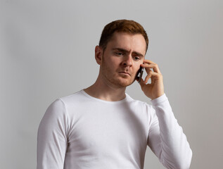 Contemporary young man poses in studio.Talking on the phone.