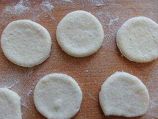 Cooking yeast dough. Working with dough in the kitchen. Close-up on rolled out dough.