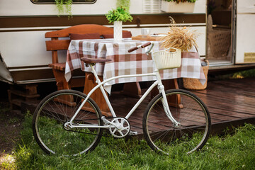 Camping season. Photo studio. Bicycle on the background of the trailer