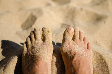 wet feet of a man on a sandy beach