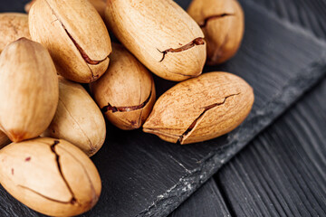 delicious fresh pecans on a black rustic wooden background