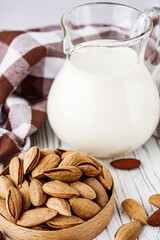 almond milk on a white wooden rustic background