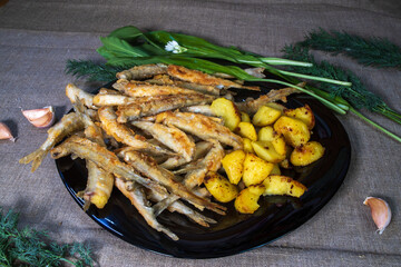 Fried smelt with potatoes on a plate