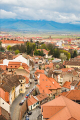 Obraz premium Aerial cityscape of historic Sibiu city in Transilvania, Romania, and cloudy Carpathian mountains 