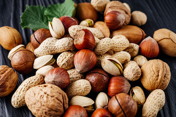 set of different nuts on a black rustic wooden background