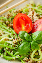 zucchini noodles with quinoa on a white background