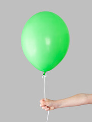 Green gel ball in hand on a gray background.