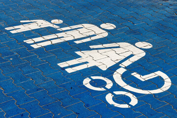 Family parking spot sign for parents with children. Blue and white sign on the ground.