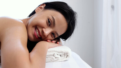 Happy Asian woman in spa salon lying on the massage desk, Beauty and spa Thai massage concept