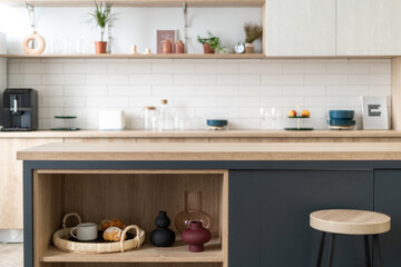 Fototapeta na wymiar Open storage cabinet with vase, home decor and breakfast tray on shelf